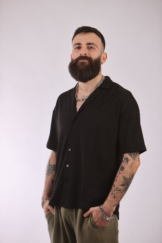 Marrakech shirt in black with short sleeves, worn by a model.
