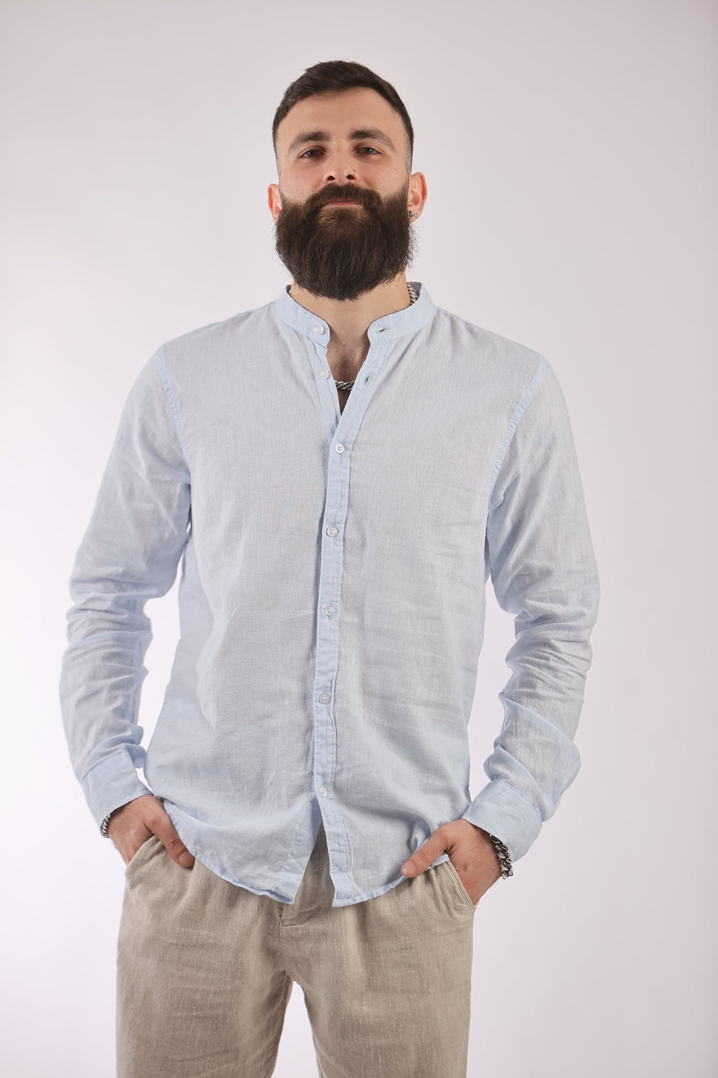 Man wearing a light blue Figo shirt with a Chinese collar, combining linen and cotton for comfort and style.