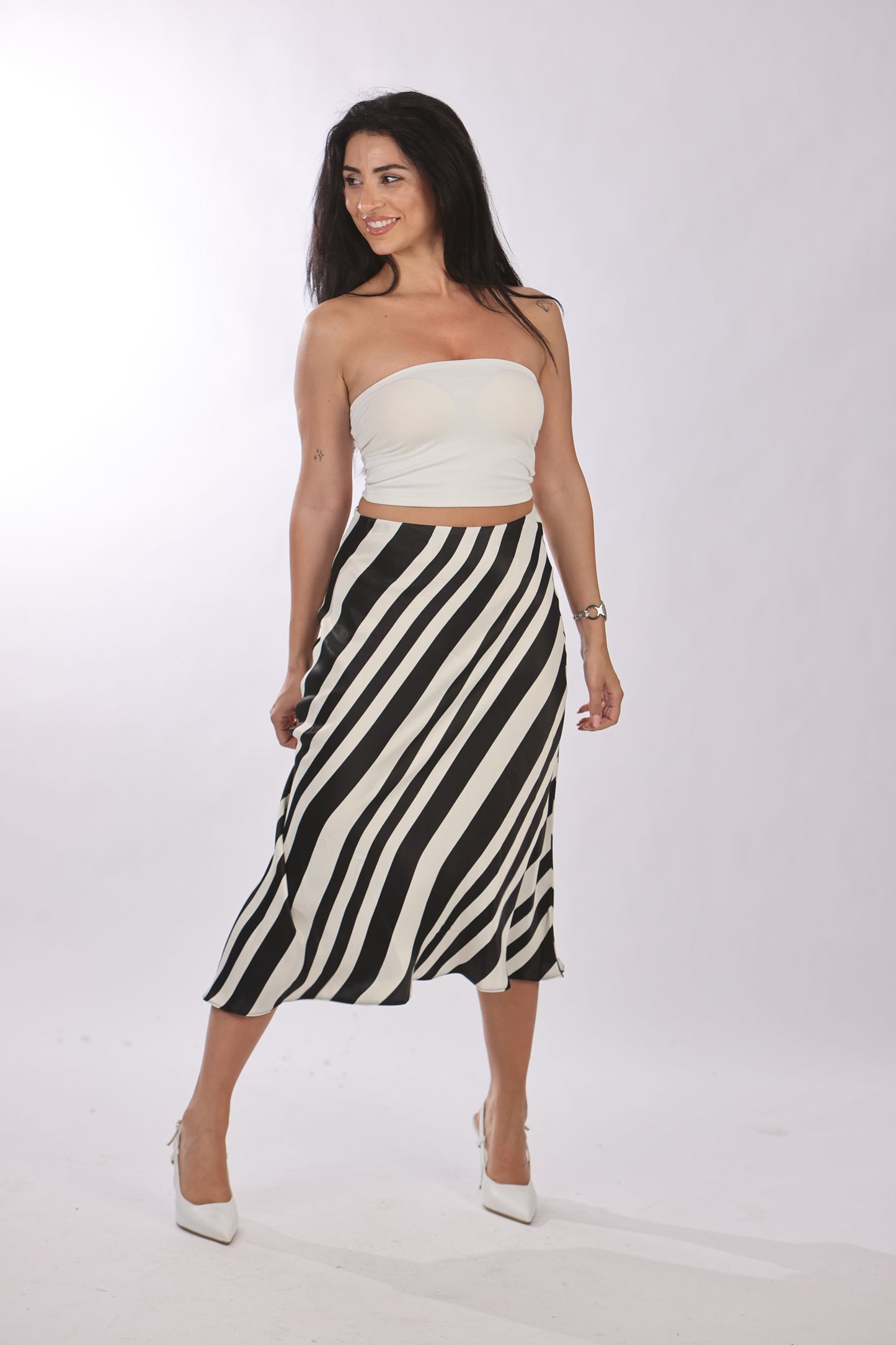 Quzu crop top featuring a comfortable, stretchy fit in white, paired with a black and white striped skirt.