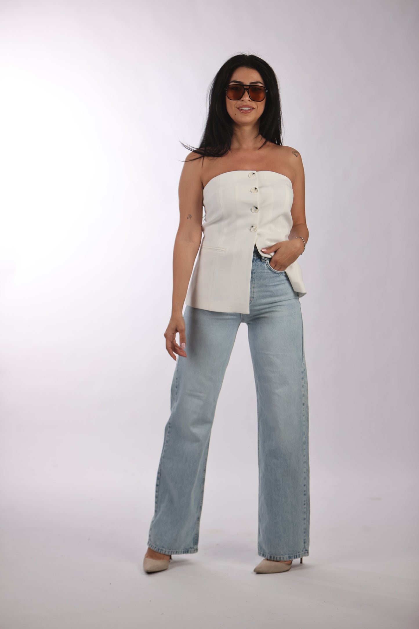 Basic straight jeans with classic washed look worn with white strapless top and sunglasses.