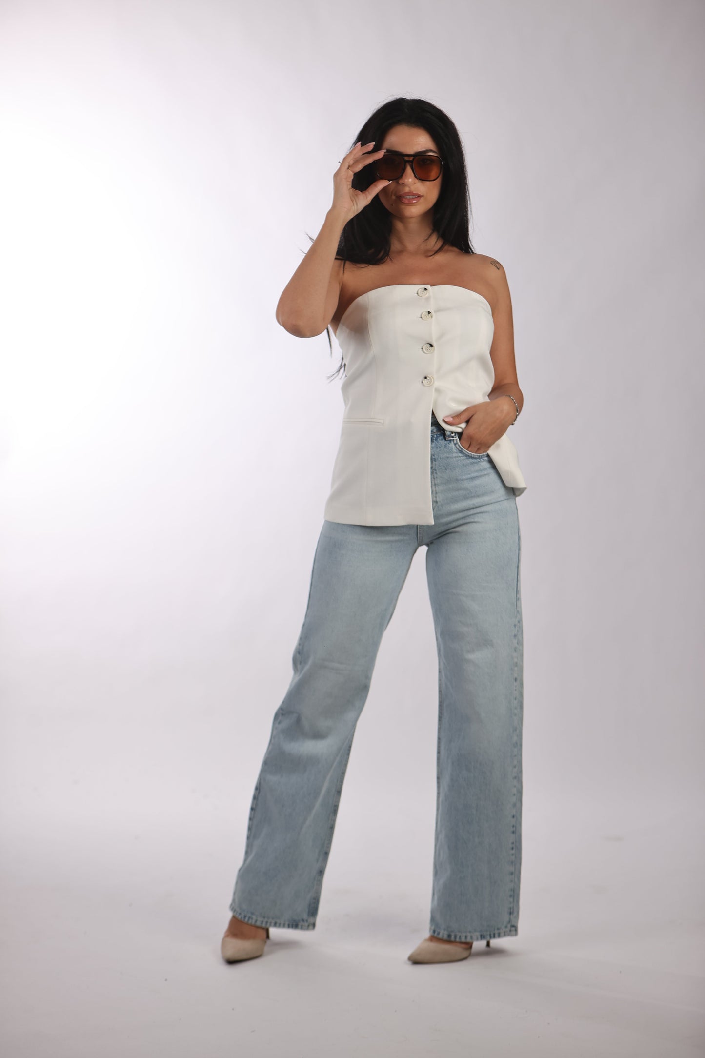 Basic straight jeans with a classic washed look, worn with a stylish white top and sunglasses.