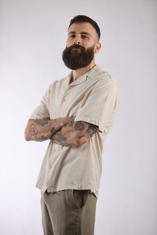 Man wearing a beige Guesto shirt made from 100% cotton.