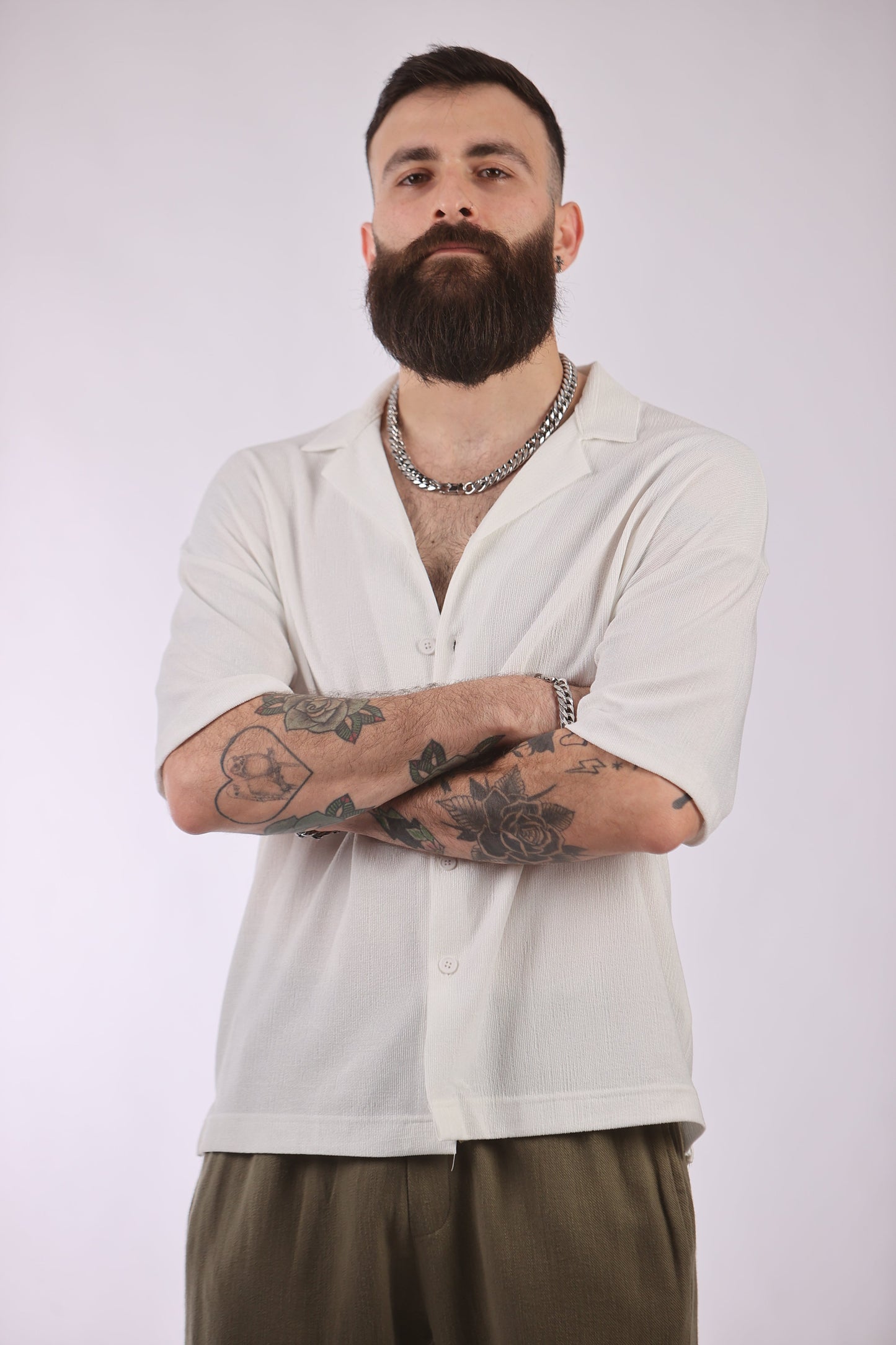 Marrakech shirt on a person with tattoos, featuring short sleeves and a button-down front.
