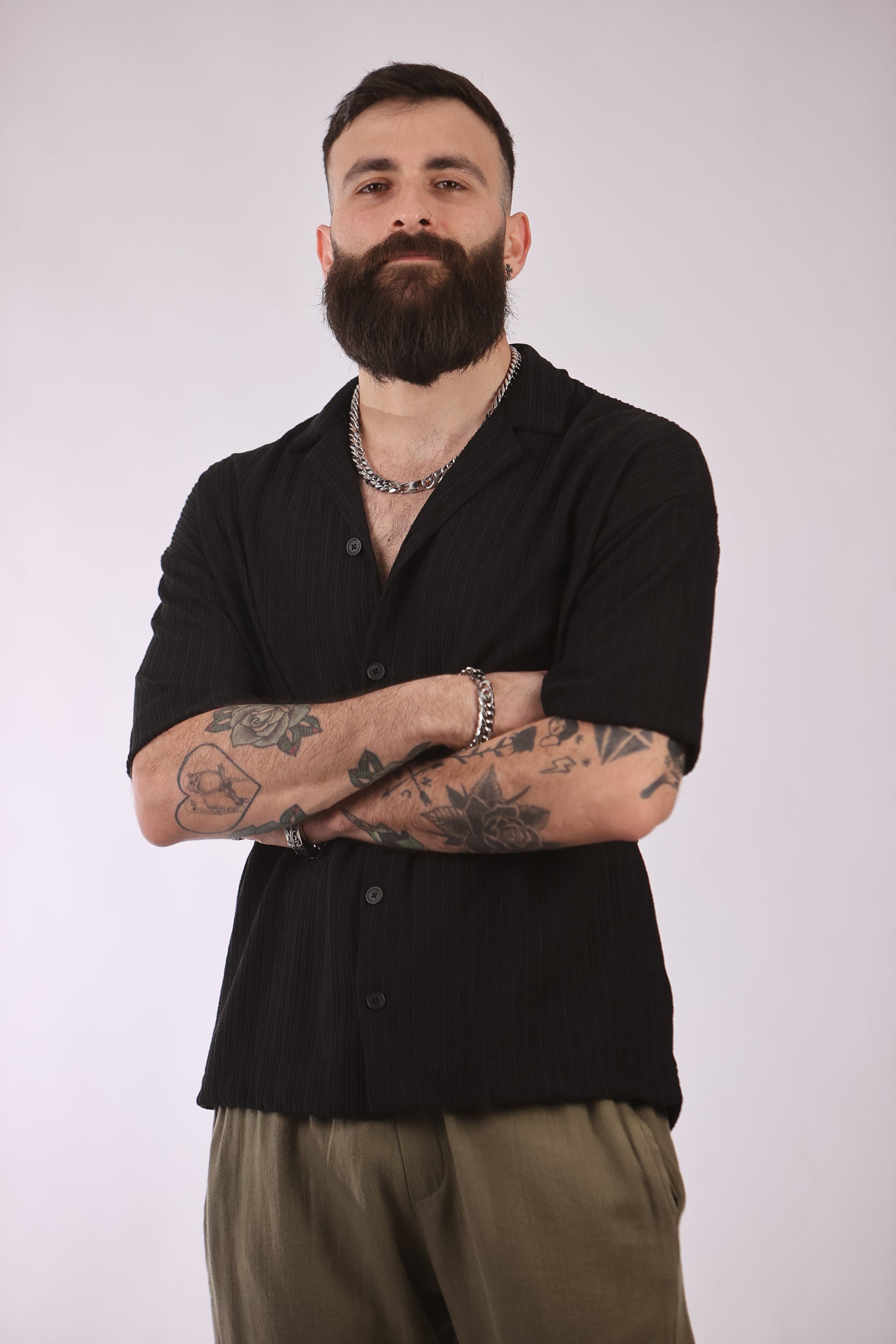 Marrakech shirt in black, worn by a model with tattoos, showcasing its comfort and flexibility.
