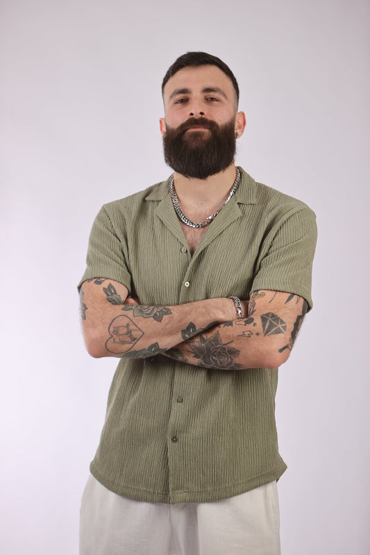 Polyester streetwear shirt in olive green worn by model.